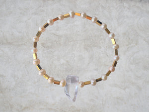 bracelet en petite perle a tendance rosée et petit tube carré en hematite. au milieu une petit cristal de roche 